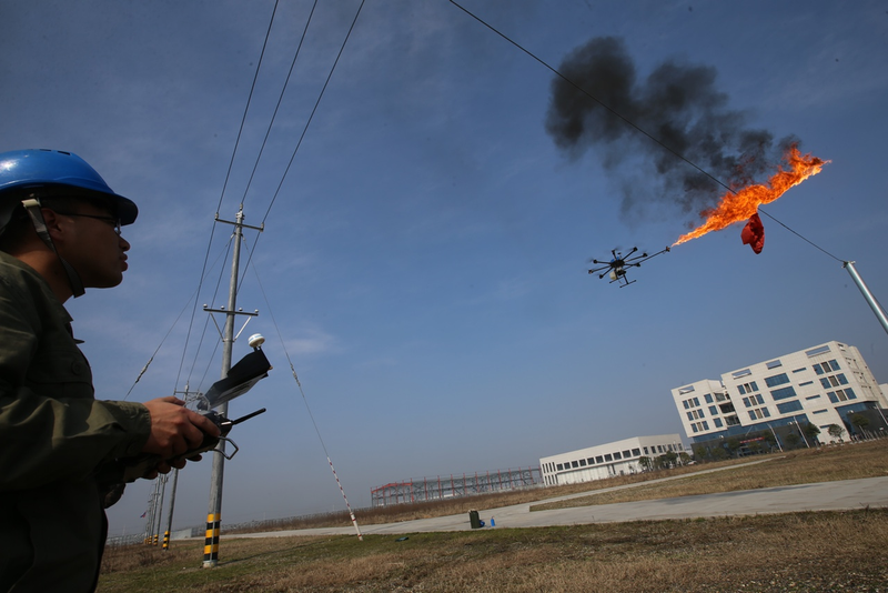 Electric company maintenance workers in Xiangyang, China used a fire-shooting drone to burn garbage from electrical wires (Photo by Wang Hu/VCG)